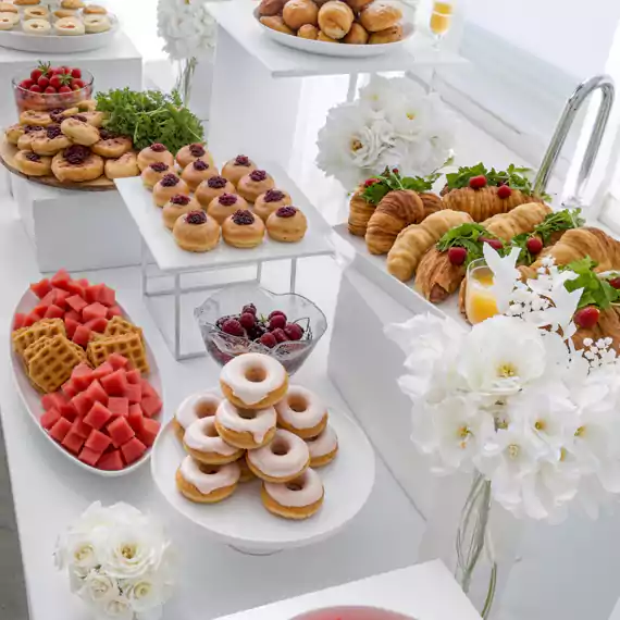Luxurious private catering setup featuring an elegant breakfast spread with fresh pastries, waffles, and fruits, perfect for exclusive gatherings in Dubai